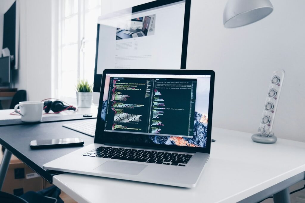 Laptop showing a code editor on a developer desk